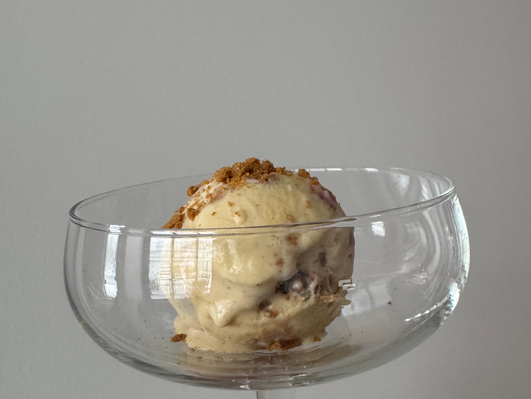 A scoop of strawberry Cheesecake icecream in a coup.