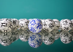 Lottery balls with numbers on in front of a green background