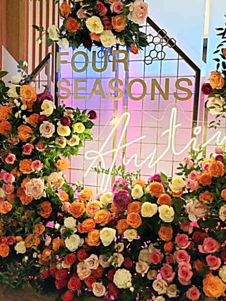 Floral arrangement with Four Seasons Austin text and colorful blossoms decoration.