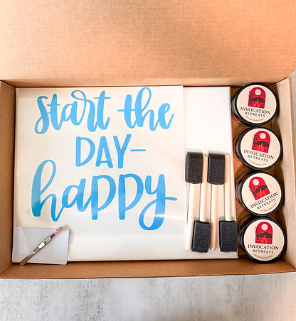 Box filled with canvas, paints and paint brush for messy canvas kit