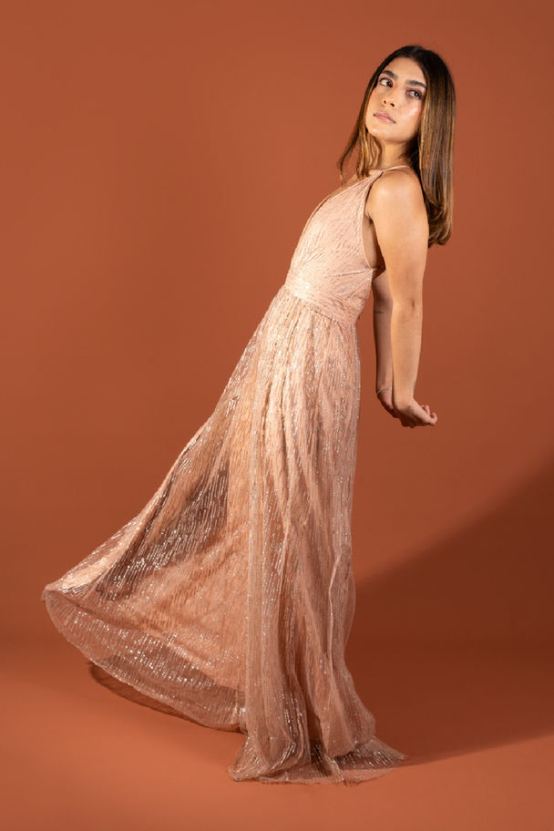 Mujer con vestido de gala colo oro rosa de marca colombiana Silvia Tcherassi