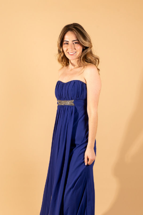 Mujer coon vestido largo de alquiler color azul petroleo, marca TEMPO y diseño colombiano