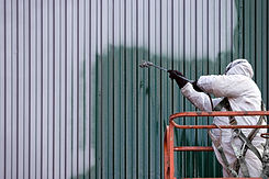 A commercial painter on an industrial li