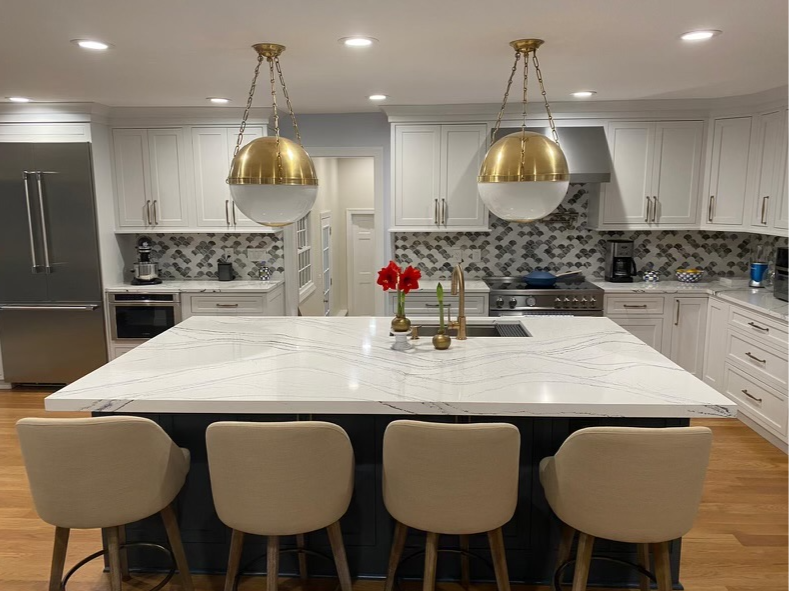 Modern kitchen island with marble countertop and brass globe pendants