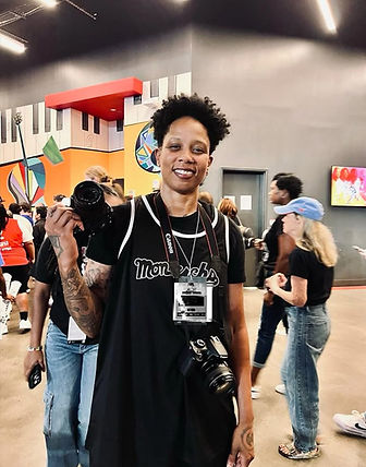 Cassie Chantel capturing media at an Atlanta Dream game wearing a black Monarch Jersey