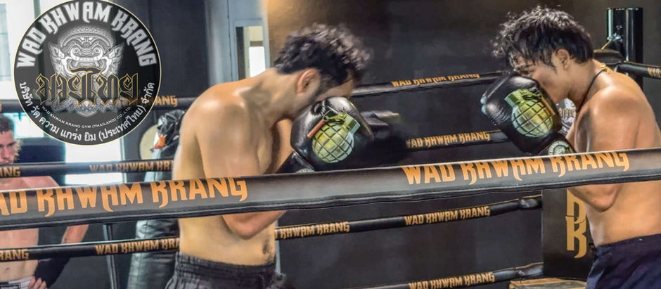 Den 'The eagle' Junlaphan sparring with Kru Yak Noi with WKK Gym logo in the top left corner
