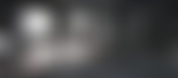 WKK Muay Thai Fighter Gym with 2 boxing rings and 6 heavy bags in teh background. WKK Gym logos and branding.