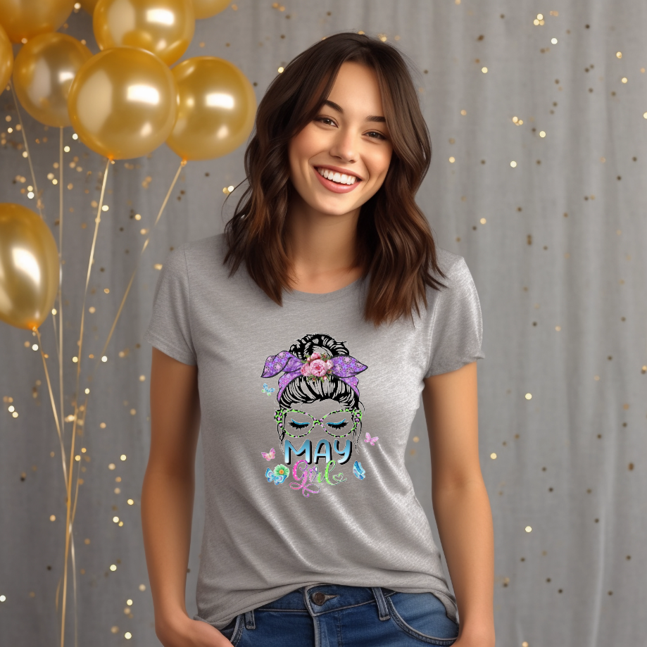 Woman graphic with a messy bun, green glittery glasses, floral bow, and butterflies above text reading May Girl.