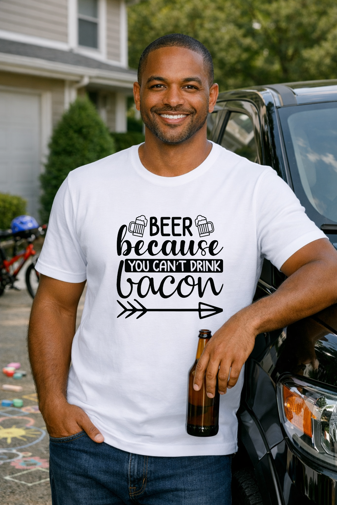 Smiling man wearing a Beer Because You Can't Drink Bacon shirt leans against a truck while holding a bottle.