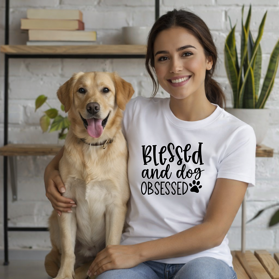 White T-shirt featuring a black βBlessed and Dog Obsessedβ graphic with a paw print, modeled beside a dog outdoors.