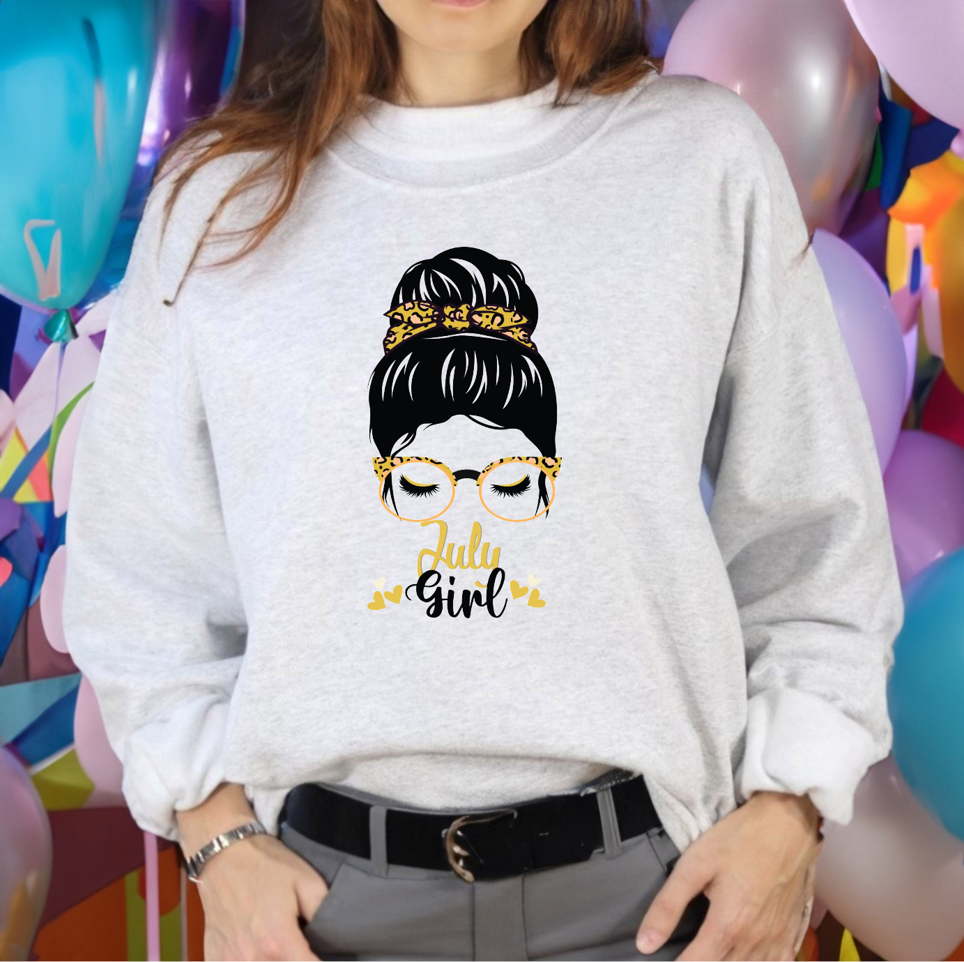 Woman graphic with a messy bun, yellow leopard print glasses, and tiny hearts above text reading July Girl.