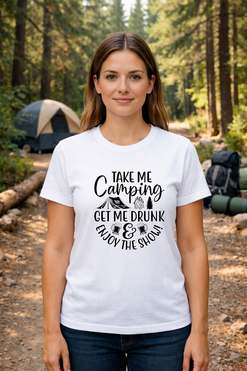Smiling woman standing in a wooded campsite area wearing a white shirt with a funny drinking and camping quote.
