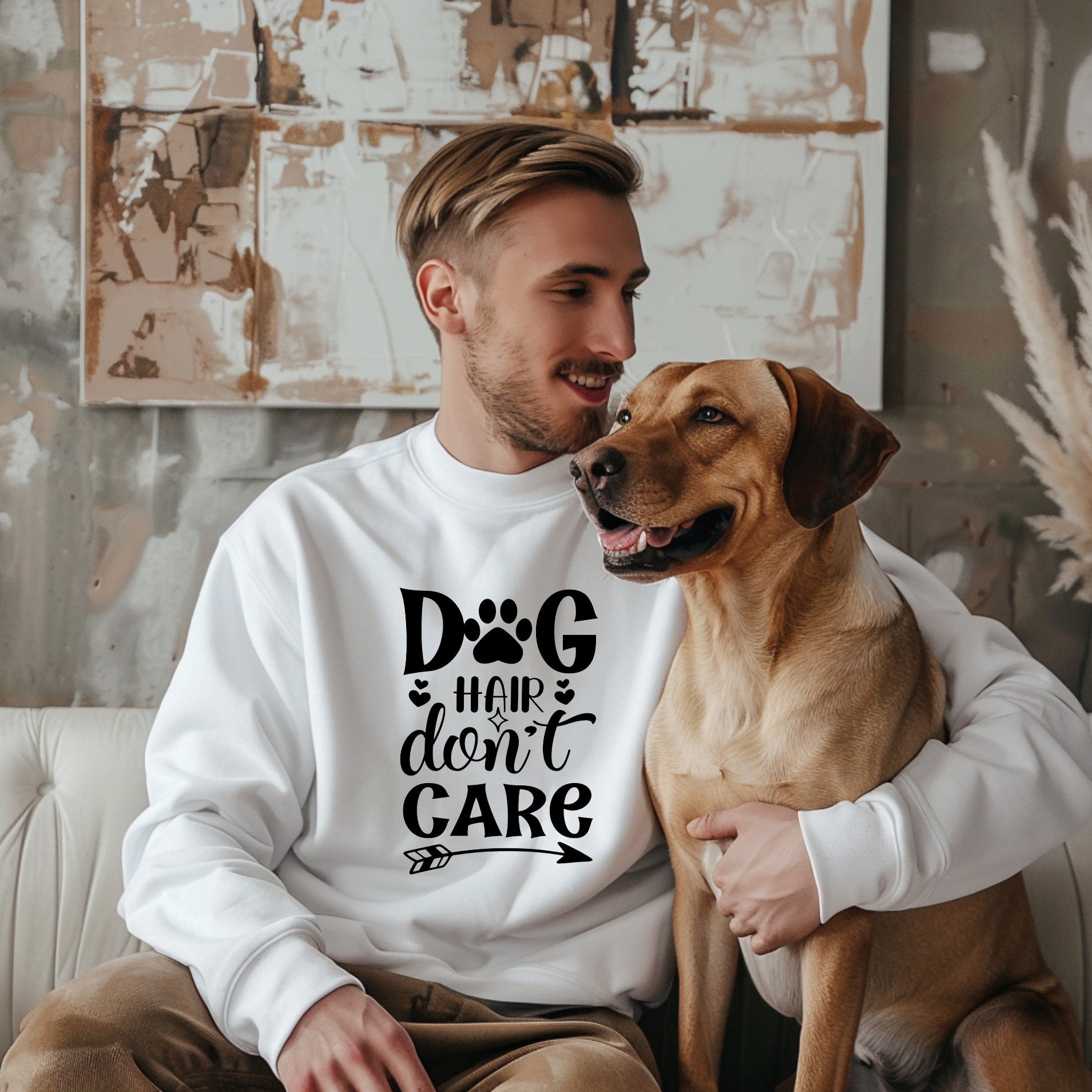 Man wearing a Dog Hair Don't Care sweatshirt while cuddling with his dog.
