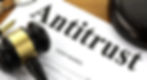 Gavel, pen, and glasses on a document titled "Antitrust Court Hearing." The image conveys a legal and formal mood.