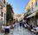 Bustling street scene in Athens with people dining and walking between buildings