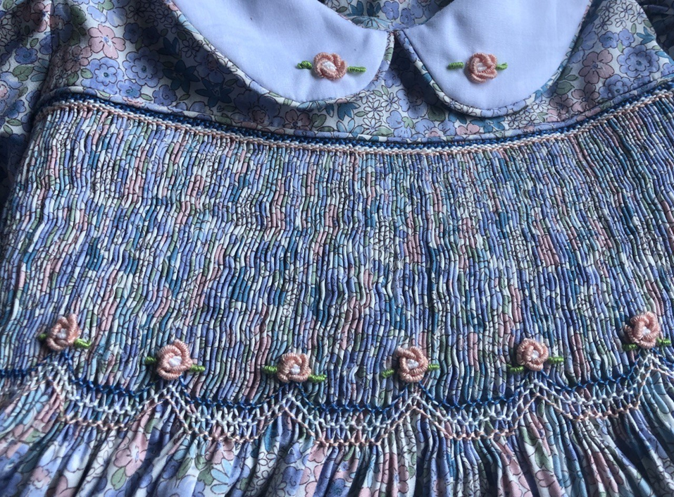 A close-up of the reverse smocking and embroidery on the front of the dress.