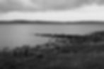 Desolate shoreline in black and white, evoke liminal spaces.