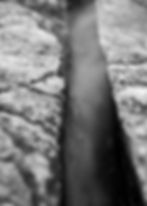 Close-up of a narrow crevice between rocks, evoking liminal spaces.