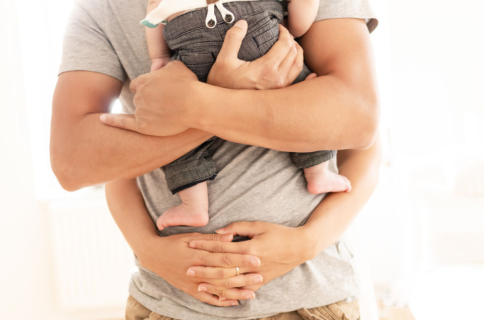 Photo couple qui prend bébé dans les bras