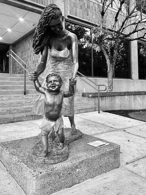 A mom holding up her son for his first steps