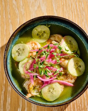 ACACIA midtown's Shrimp ceviche in a bowl with cucumbers and pickled onions served.