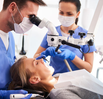 male-dentist-working-with-dental-microscope.jpg