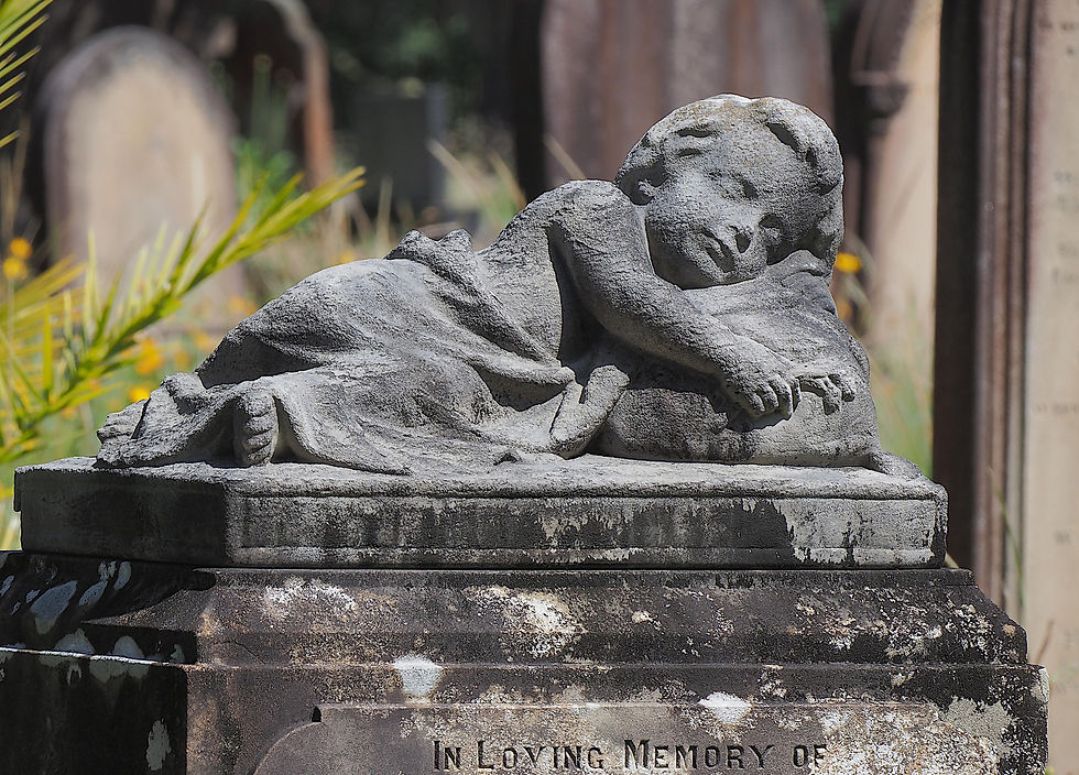 Sleeping child gravestone sculpture representing peaceful rest.