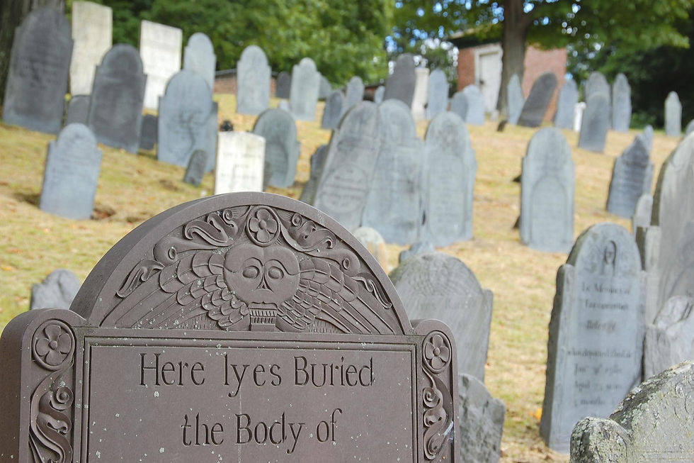 Colonial-era graveyard located beside a church building with slate headstones.