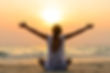 A woman sat on the beach enjoying the sunset