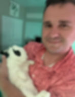 Dave holding a white rabbit indoors.