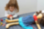 Child girl playing doctor with a toy. Profession and care concept. Clear neutral backgroun