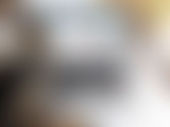 Mesa com xícara de café, caderno, papéis e notebook aberto em uma planilha