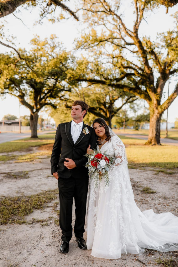 Bride and groom standing under oak trees