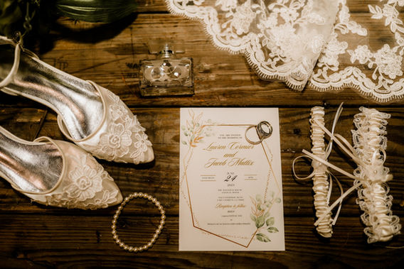 Bridal invitation, lace shoes, and wedding accessories