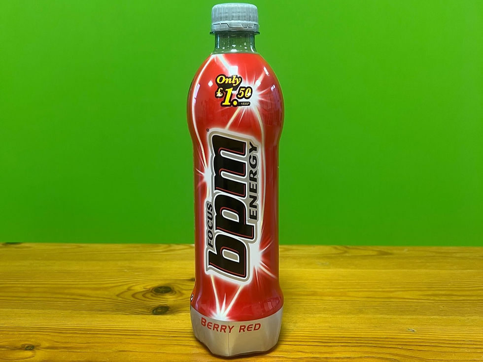 Red energy drink bottle labeled "bpm Focus" and "Berry Red" on wooden table, green background