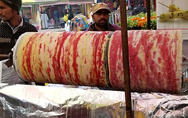 Imgae of a spit of fruit kulfi (fruit ice cream) in Dilli Haat (artisan shopping center) in New Delhi