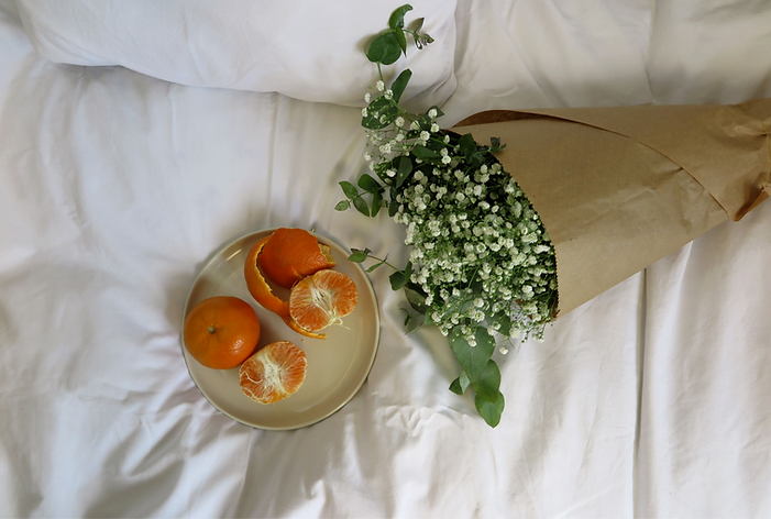 Plate with oranges and flowers next to it.