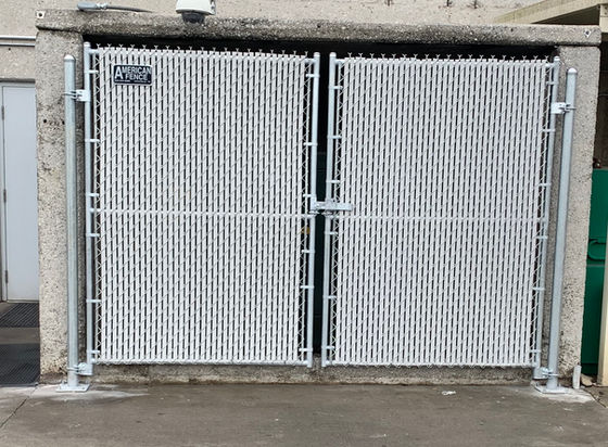 A white chain-link gate covering an entrance in a building