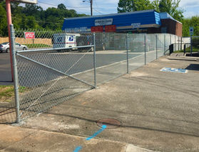 A chain-link fence next to a blue-roofed store