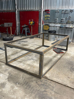 A metal frame placed on a concrete floor, emphasizing a raw and industrial environment.