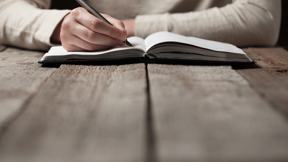 Mulher escrevendo em um caderno sobre a mesa de madeira