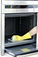 Woman professionally cleaning a dirty oven