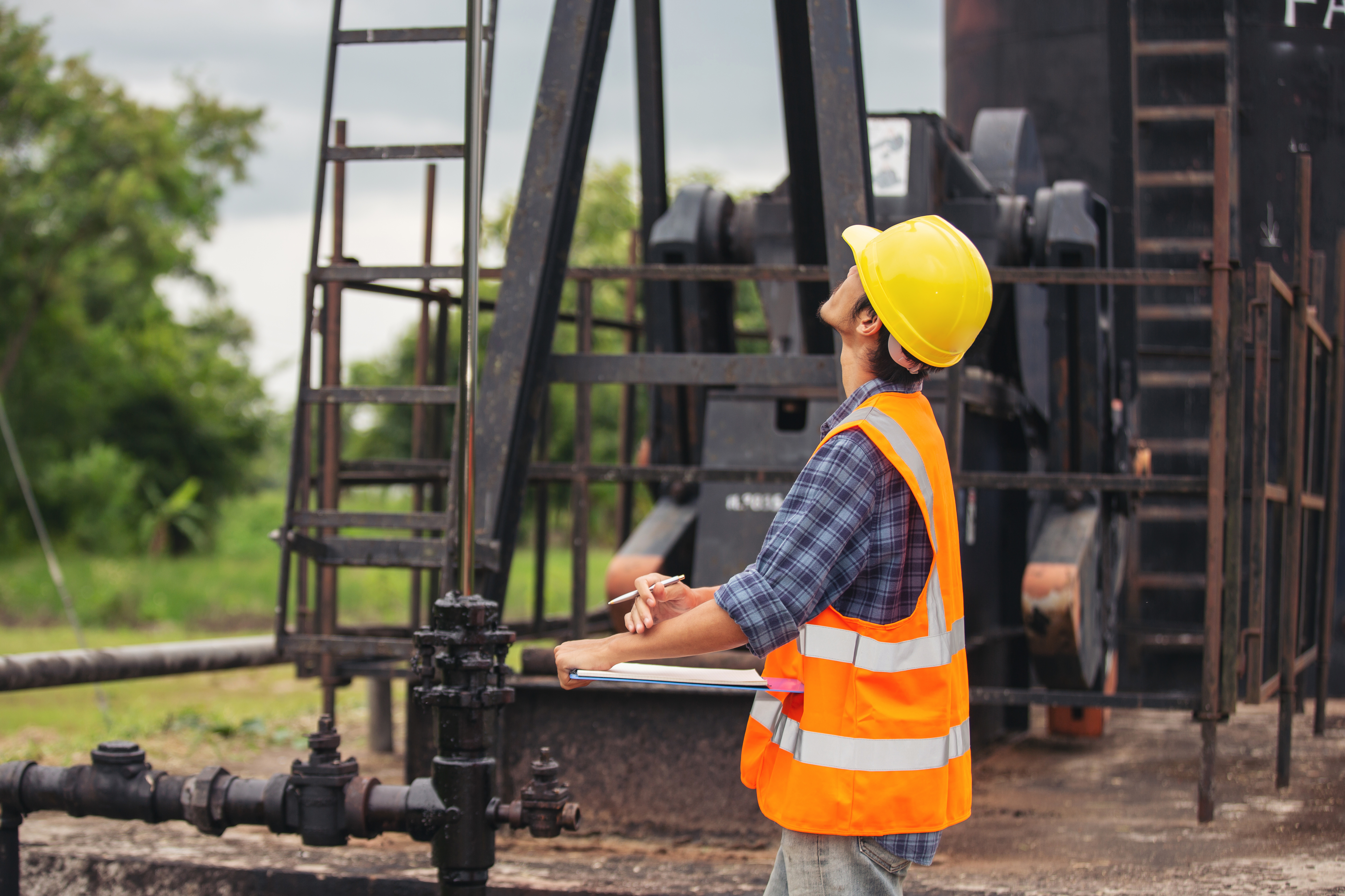 workers-standing-checking-beside-working-oil-pumps.jpg