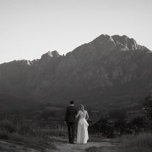 Couple walking together with a mountain backdrop at sunset at their Zorgvliet Wedding outside Stellenbosch