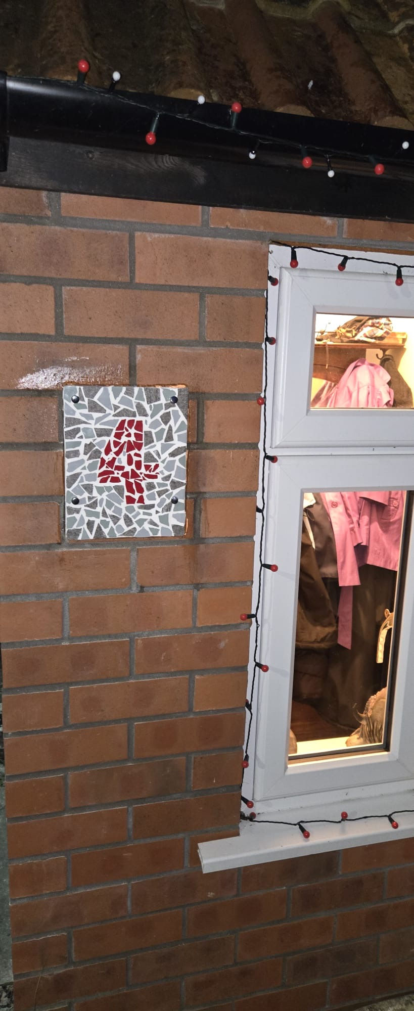 A number 4 mosaic door plaque installed on a wall