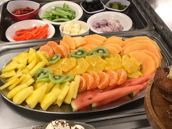 Platter of fresh cut fruit and salad ingredients