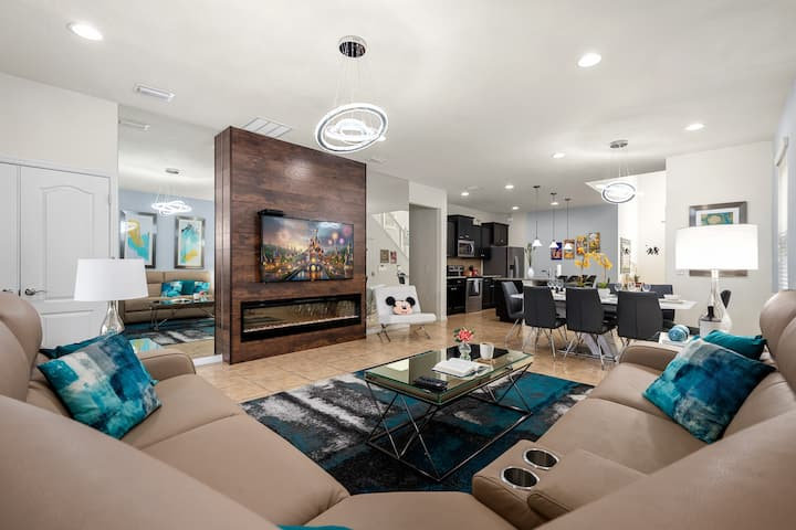 Open living room with leather sectional and a fireplace media wall