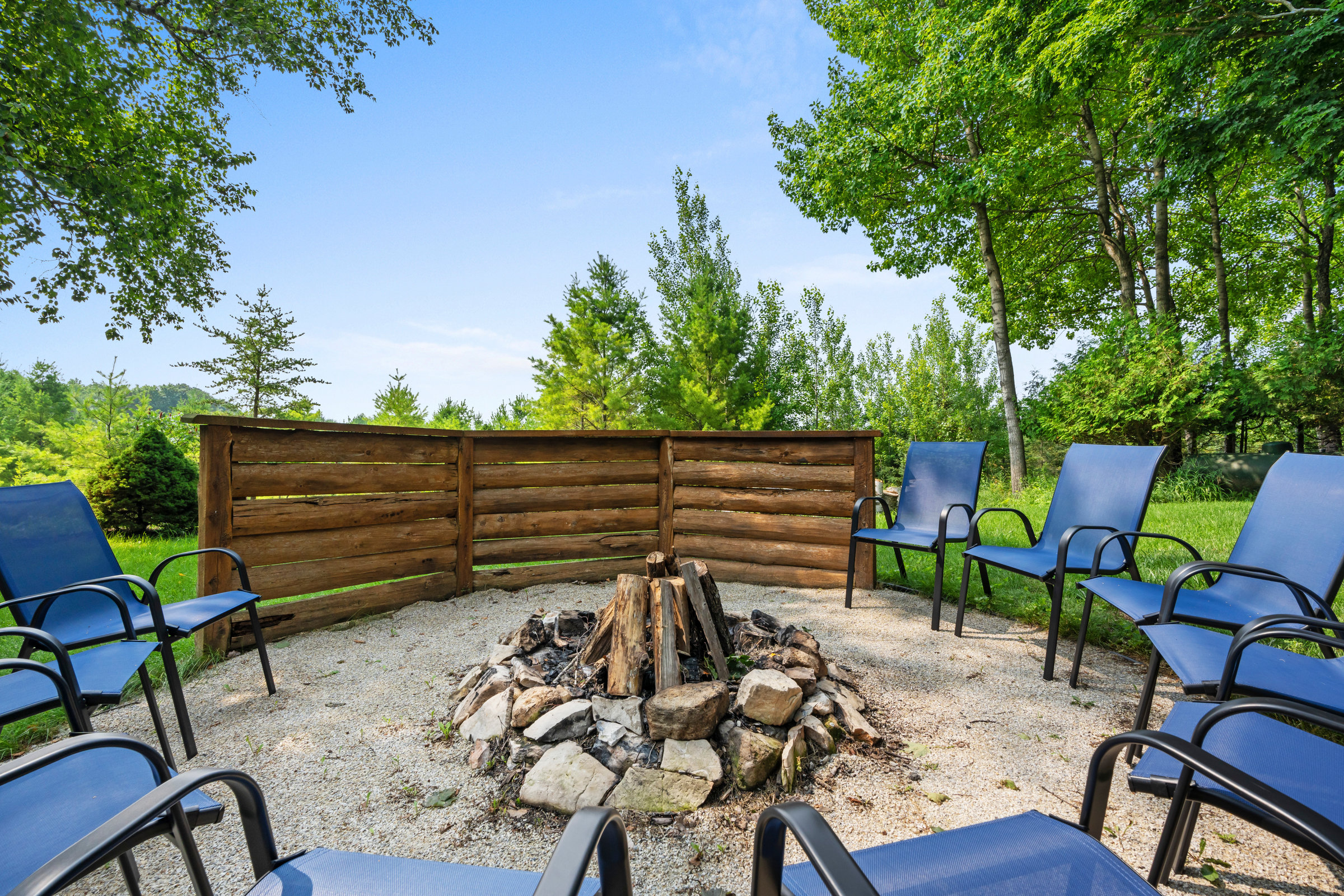 Fire pit circle with blue chairs on the lawn