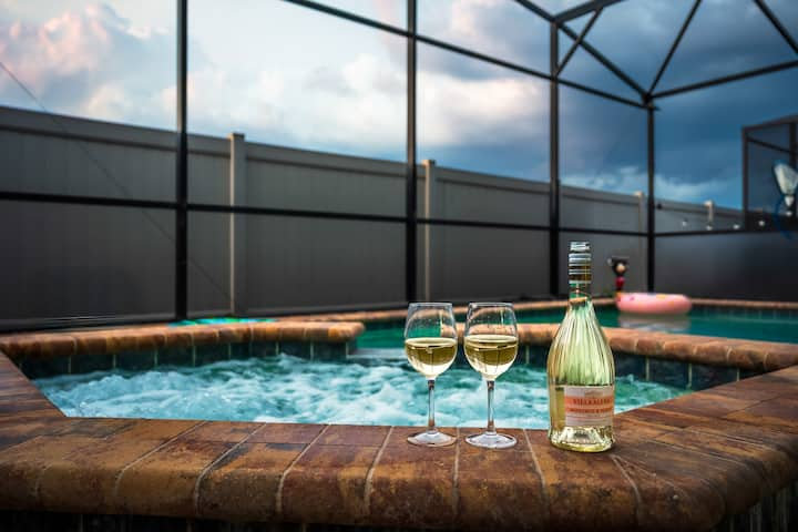 Two glasses of wine on the spa edge by the pool