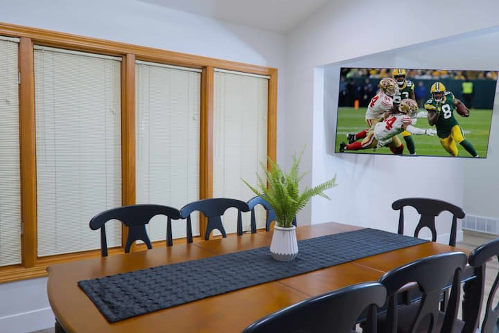 Dining table for six with the game on the wall TV